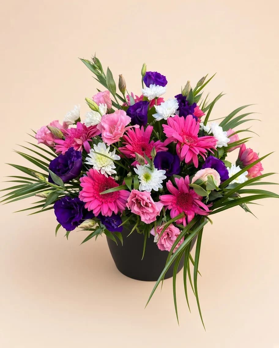 Siyah saksıda fuşya gerberalar, mor lisianthus ve pembe karanfillerden aranjman